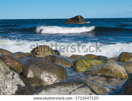 Picture of Baltic sea. Nice amazing sunny day. Wet slippery stones on the beach. Lots of boulders and rocks at the beach. Small waves hitting the shore. Ocean. Good fishing spot on Juminda Peninsula