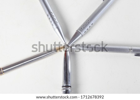 several gray ballpoint pens on a white background
