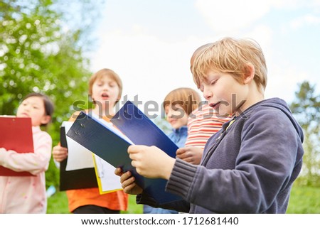 Children on a treasure hunt or scavenger hunt with clipboard in nature Royalty-Free Stock Photo #1712681440