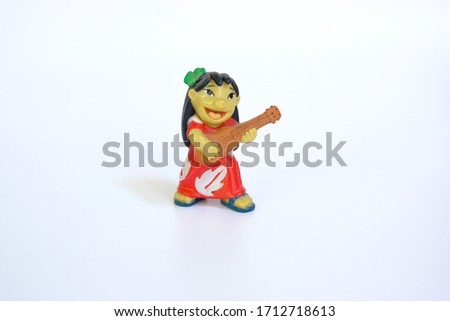 Hawaii girl figure with 4 leaf clover on the head and ukulele