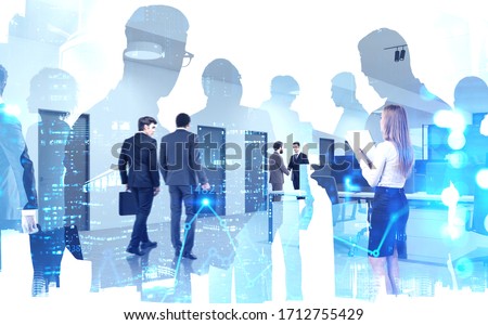 Blurry diverse business people working together in modern open space office with double exposure of night cityscape and financial graph. Concept of stock market and teamwork. Toned image