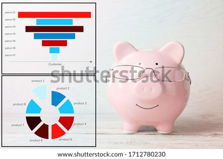 Pink piggy bank with glasses and graph on light background