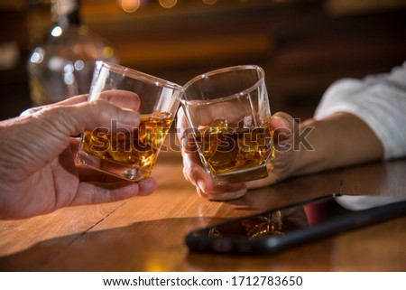 hands toasting whisky in pub