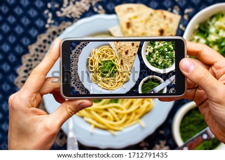 Create blogging content, make phone food photo of vegan lunch. Smartphone meal picture of Italian pasta spaghetti with pesto spread.