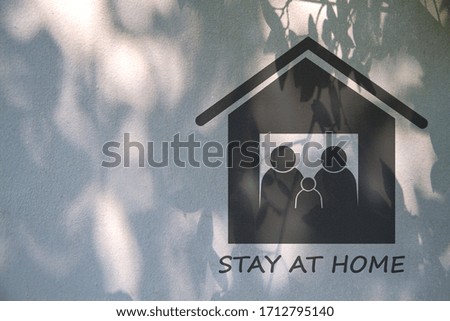 Sign, Symbol stay at home with shadow of leaves on white cement wall. protect coronavirus covid-19. stay at home concept