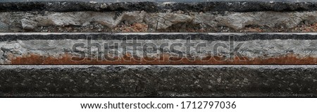Layered asphalt road side texture with soil geology cross section underground earth, cutaway tar road  terrain surface Royalty-Free Stock Photo #1712797036