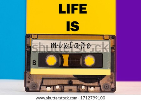 Top view of audio cassette with Life is a mixtape inscription on colorful background