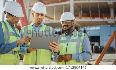 Diverse Team of Specialists Use Laptop on Construction Site. Real Estate Building Project with Engineer Investor and Businesswoman Checking Area, working on Civil Engineering, Discussing Strategy Plan Royalty-Free Stock Photo #1712804146