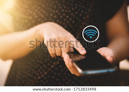Woman hand hold using smart phone at outdoor park street with wifi icon abstract background. Copy space of technology business and travel holiday concept. Vintage tone filter effect color style.