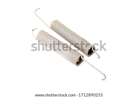A pair of metal springs for replacement in an atomic car on a white isolated background in a photo studio. Spare parts for repair in a car workshop, for sale.