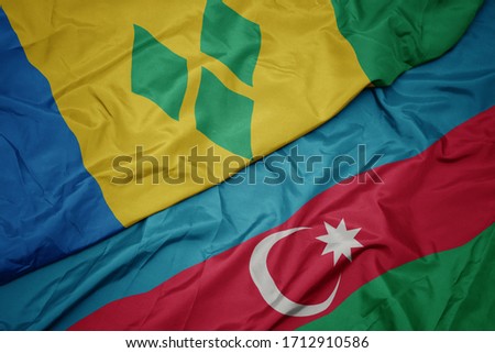 waving colorful flag of azerbaijan and national flag of saint vincent and the grenadines. macro