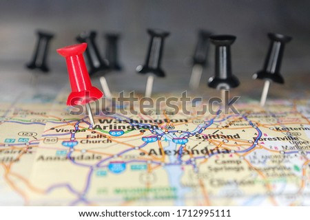 Macro shot of a red pushpin marking the White House in a map surrounded by black pins. Royalty-Free Stock Photo #1712995111