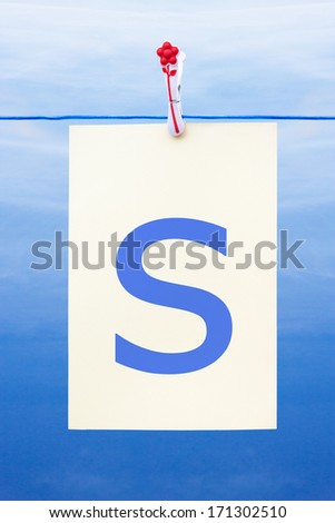 Seamless washing line with paper against a blue sky showing the letter s