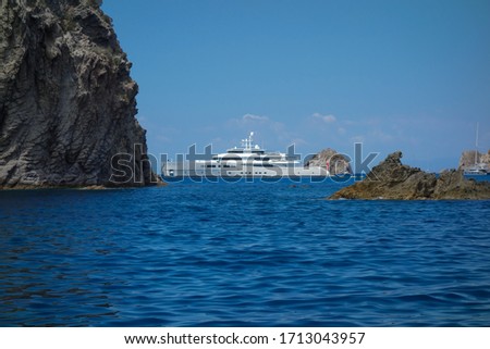 View of the rocky coast in Ponza island with a wonderful luxury yacht in the background (Latina, Italy).