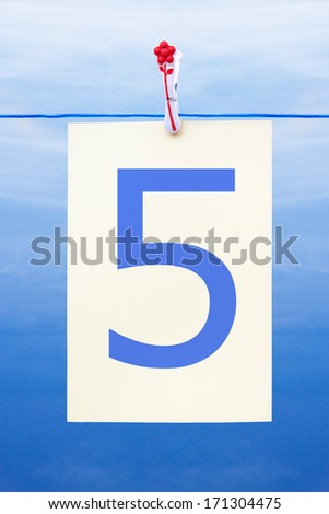 Seamless washing line with paper against a blue sky showing the number 5