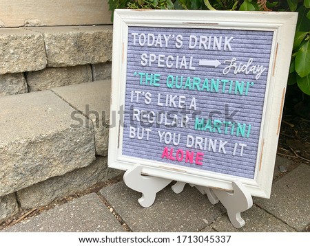 Rustic wooden sign with a daily special spelled out. Inspirational or motivational quote or meme. Felt letter board with multicolored letters on a sidewalk by concrete stairs.