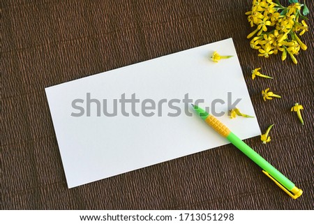    blank paper, pen and yellow flowers. free space for text                             