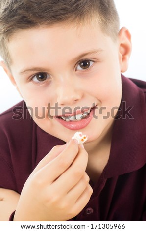 Young boy eating popcorn.