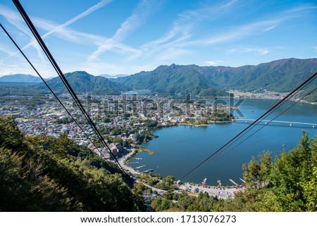 The view of Kawaguchiko lake at Fujyoshida town take from Mt. Fuji panoramic ropeway on the sunny day with the clear blue sky. Royalty-Free Stock Photo #1713076273