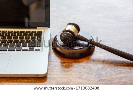 Auction law gavel and a computer laptop, wooden office desk background, closeup view, Online auction, cyber crime  concept