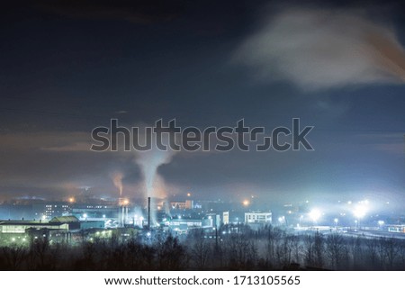 
Factory lit by lights and shrouded in fog in the night