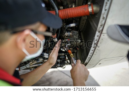 Mechanic use torque wrench on aircraft engine Royalty-Free Stock Photo #1713156655