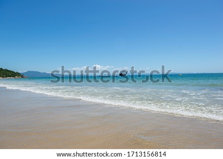 View of beautiful beach in Florianópolis - Brazil. large wooden sailing vessel in turquoise sea under beautiful clear sky. Pirate ship used for tourist tours. Selective focus. Copy space.