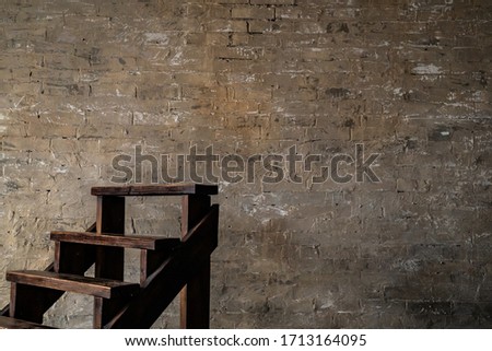 Dark wooden stair near to an old brick wall. Short stair. Horizontal photo