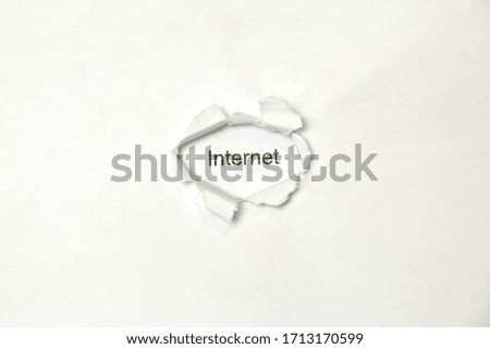 Word internet on white isolated background, the inscription through the wound hole in the paper. Stock photo for web and print with empty space for text and design.