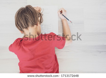 young boy studying at home on the floor