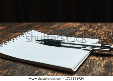 An empty paper note with a pen. The Concept Of A Business Plan. Workplace with a coffee Cup, on a wooden table