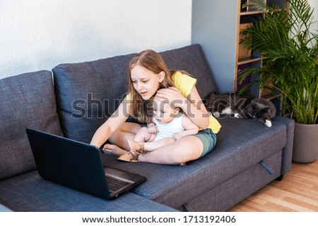 Caucasian sisters chatting online using laptop for video call.