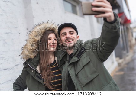 International beautiful couple walking around on the street and making photos of them
