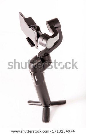Motor stabilizer for video recording on a white background, top side view. For time-lap shots with smooth movement and subject tracking. Video gimbal for smartphones and action cameras.
