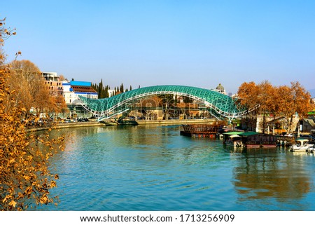 Autumn on the Mtkvari river with Peace Bridge or Glass Bridge crossing the heart of Tbilisi, Georgia. Iconic modern architecture of Georgia. Royalty-Free Stock Photo #1713256909
