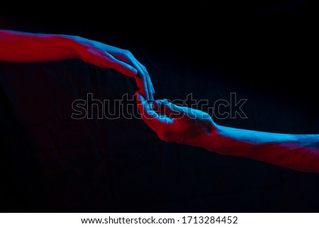 touch of hands in blue-red light