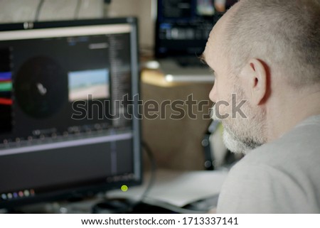 Rear View Of Professional Photographer Or Videographer Works in Photo Editing App / Software on His Personal Computer. Working from home