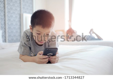 asian chinese boy playing smartphone, kid use phone and play game, addicted game and cartoon, 
