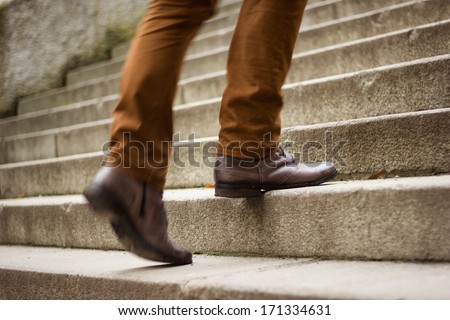 Walking upstairs: close-up view of man's leather shoes  (motion blurred image) Royalty-Free Stock Photo #171334631