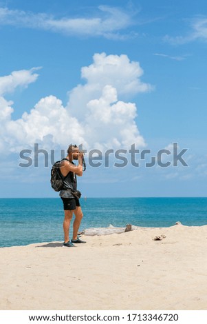 Man on beach with camera take photo   