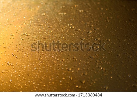 blurred abstract background,natural dew droplets on the glass the morning and the sun shines orange.