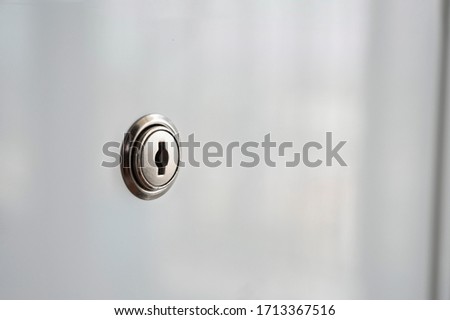 Keyhole of white acrylic material surface desk drawer background. Concept for security information or keep secret use for business or promise.