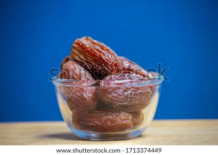 Glass bowl of dried dates. Royalty-Free Stock Photo #1713374449