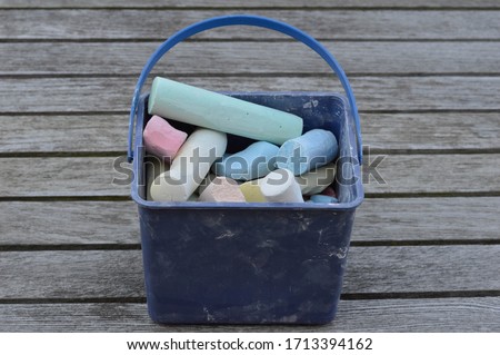 Pieces of chalk in a blue box. A toy that draws on the street. Different colors of chalk that can be used to draw on the sidewalk, mostly used by kids to play on the streets and have fun. 