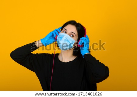 The caucasian girl in blue colored protective face mask. The girl looking at camera. Portrait shot over pink background. virus and pollution protection concept.