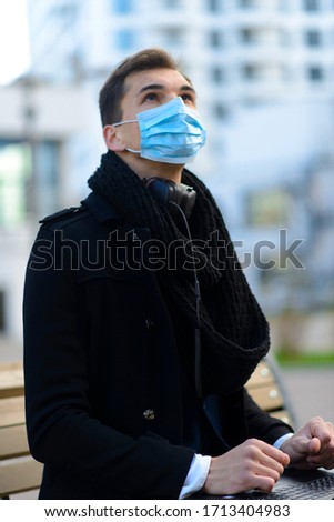 People with face mask. Concept with copy space. Portrait of adult man in quarantine of flu. Photo on the street in the city