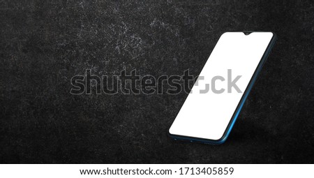 Smartphone on dark cement background. Mock-up, with isolated blank screen to use your own mobile app. 