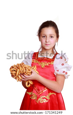 Image of pretty little girl with round cracknel isolated over white background on Holiday theme/Nice young girl with lovely smile wearing traditional russian costume 