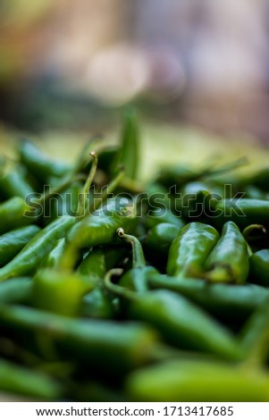 Green chilli peppers for sale at street market. Green Chillis freshly plucked at the farm. fresh produce market with close-up view of pile of green chilli peppers