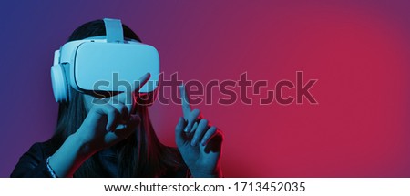 Cheerful girl with hands up wearing the virtual reality goggles.